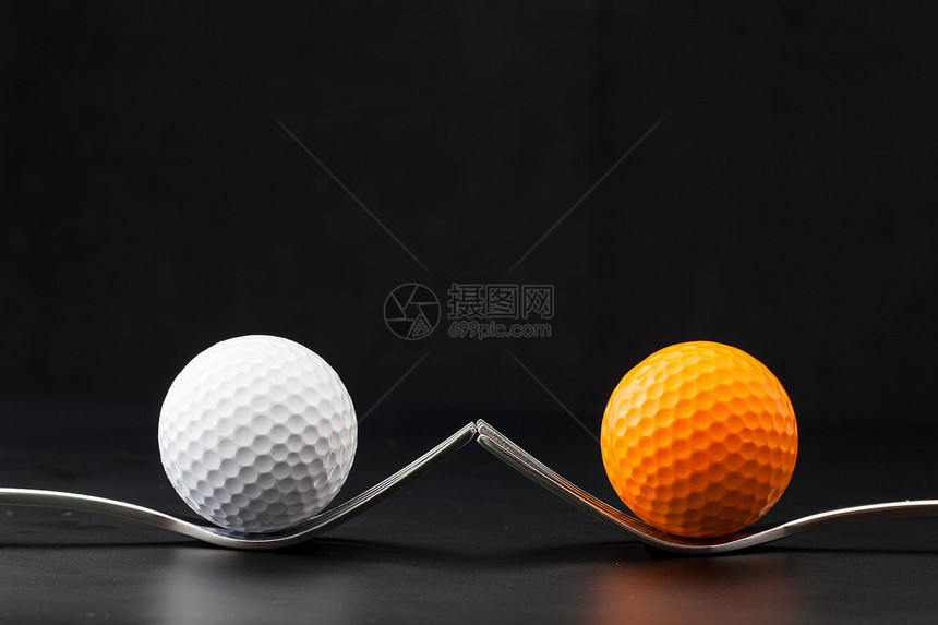 黑色背景的高尔夫球运动不锈钢木头桌子材料合金圆圈白色图片