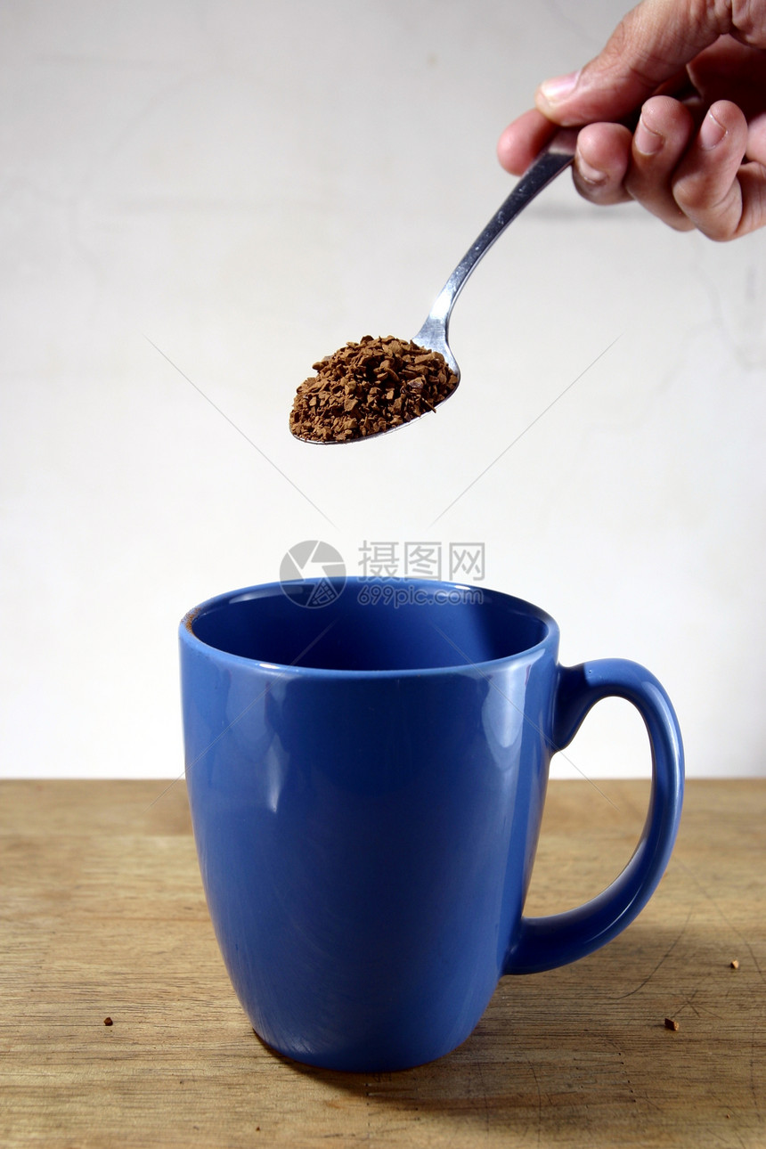 把咖啡泡在杯子里谷物蓝色勺子茶匙饮料豆子图片