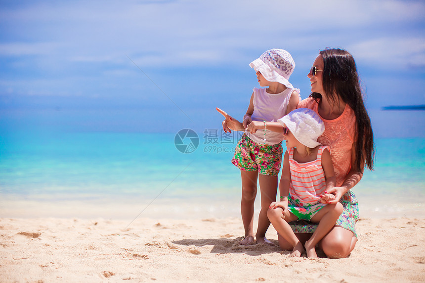 母亲和两个孩子在阳光明日海滩上妈妈海岸线假期女孩海洋婴儿微笑海岸晴天童年图片