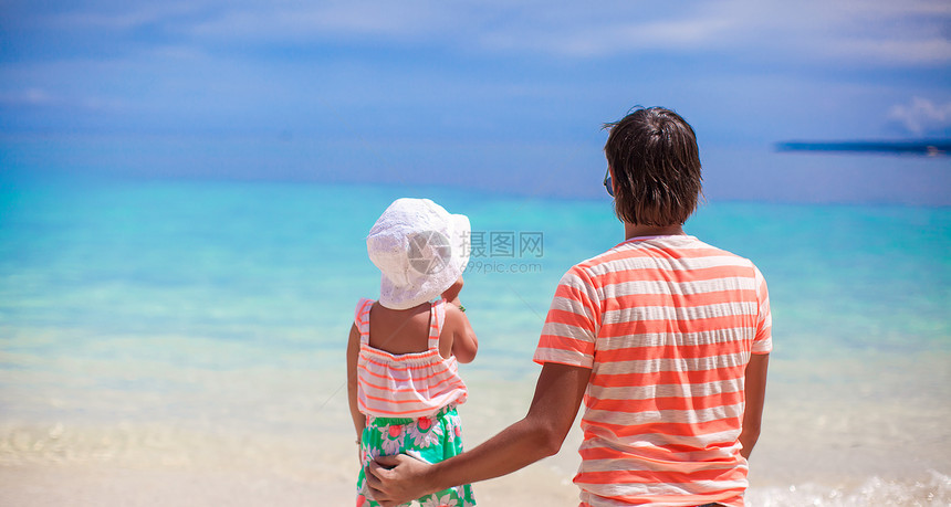 看着大海的小女孩和年轻父亲的背影海岸线男人热带幸福女孩爸爸父母海滩假期异国图片