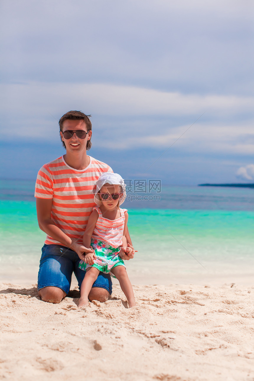 父亲和小女儿在白沙滩上放松海岸线父母家庭幸福异国成人女孩婴儿热带孩子图片