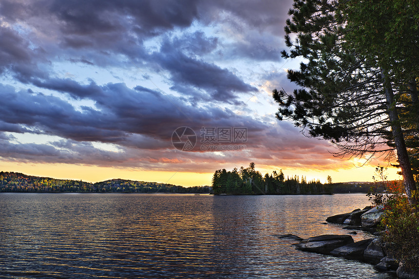 湖边戏剧性的日落荒野环境天空反思木头反射森林地平线树木图片