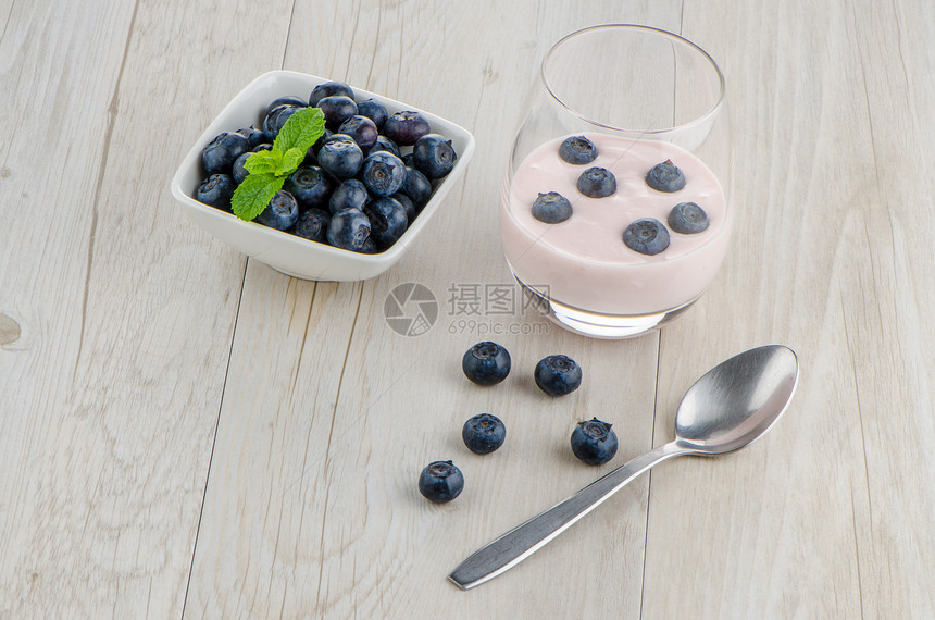 带新鲜蓝莓的酸奶营养甜点宏观蜂蜜蓝色桌子工作室木头浆果小吃图片