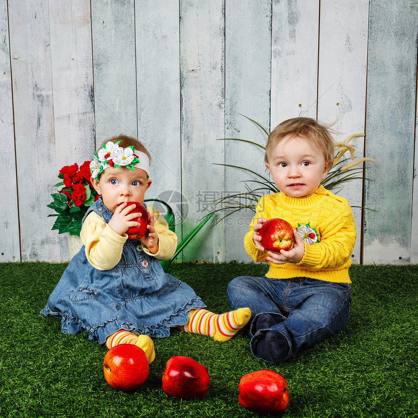 兄弟姐妹在草坪上玩耍闲暇女儿水果食物微笑男性孩子们快乐家庭兄弟图片
