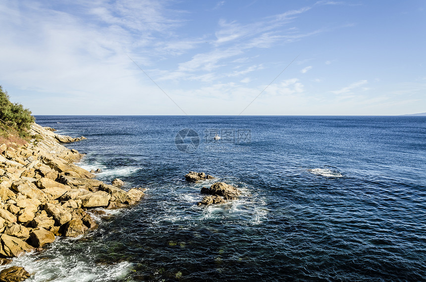 海洋中的岩石黄色流动海浪石头固体天空蓝色波浪图片