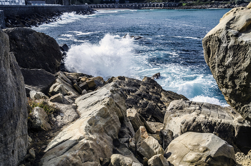 海洋中的岩石海浪流动天空波浪蓝色石头黄色固体图片