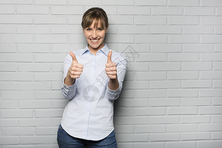 快乐的年轻女性展示缩略图标志 隔着一面墙背景图片