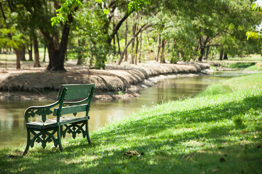 在公园的座椅上树叶风光场景季节衬套小路时间池塘座位田园图片