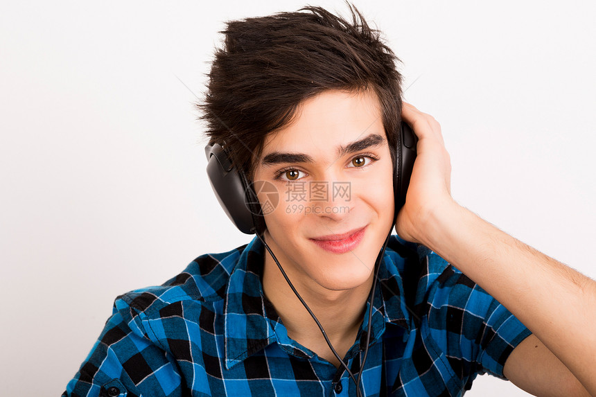 年轻人在家里用耳机监听音乐享受闲暇男性眼睛黑色立体声压力乐趣爱好音乐播放器图片
