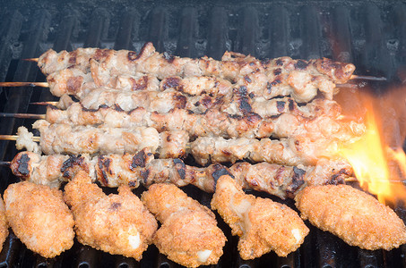 鱼叉和烤鸡翅在烤架上香气营养花环火焰食物牛肉午餐肋骨鸡翅猪肉背景图片