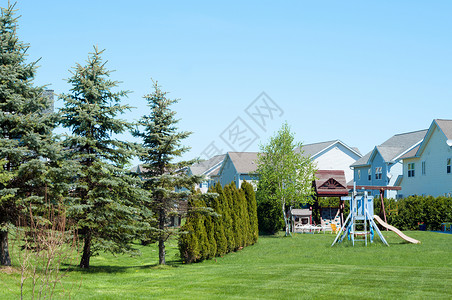 典型的美国后院 有儿童游乐场绿色建筑学蓝天财产土地花园露台房子背景