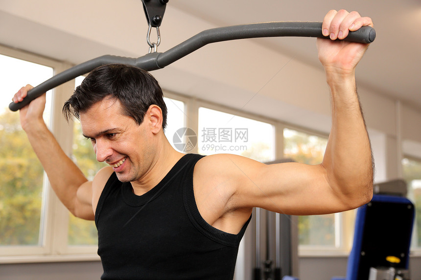 帅哥在健身房打工身体肌肉权重运动装运动员俱乐部重量哑铃机器运动图片