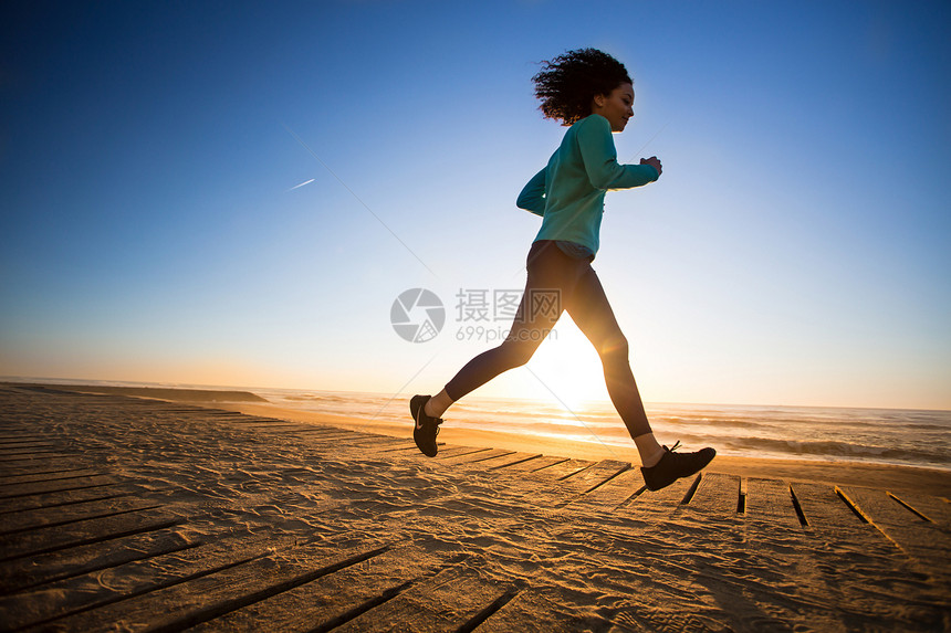 竞选的非洲裔妇女海滩天空拉丁女性日落爆炸海岸城市赛跑者训练图片