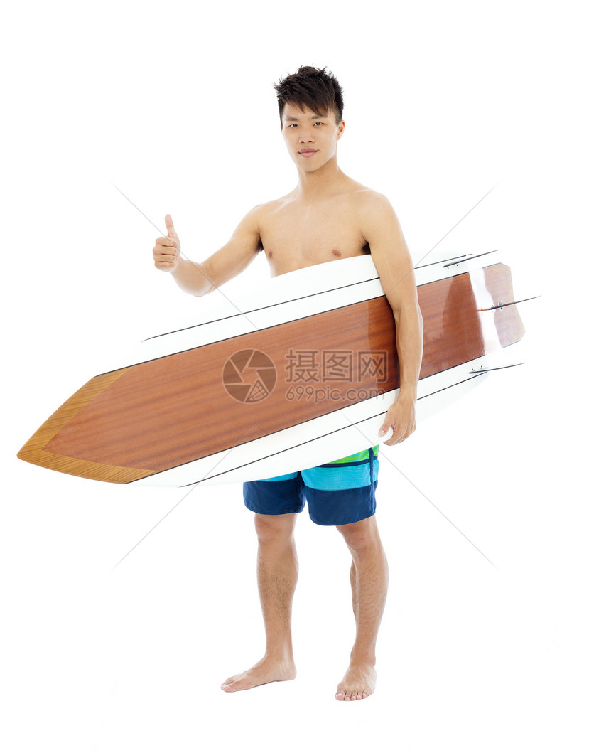 年轻冲浪手拿着冲浪板和拇指图片