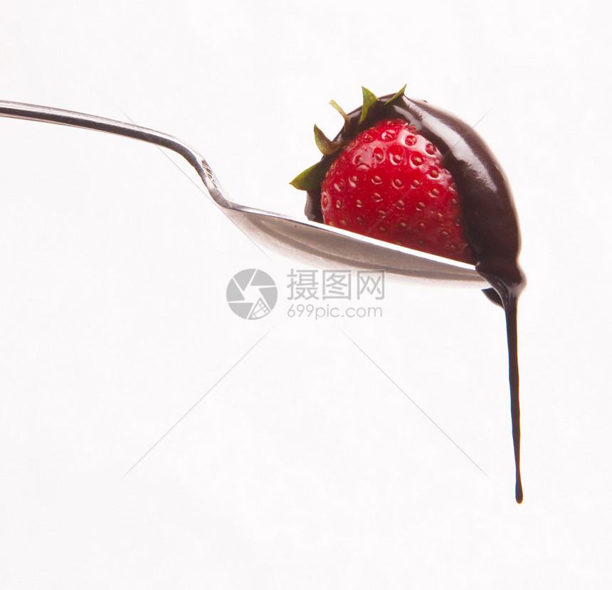 原生食物红草莓在勺子上坐着的巧克力拉特图片