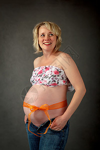 怀着小肚子的美丽的怀孕女孕妇微笑腹部母性女性生活婴儿妈妈女士白色父母背景