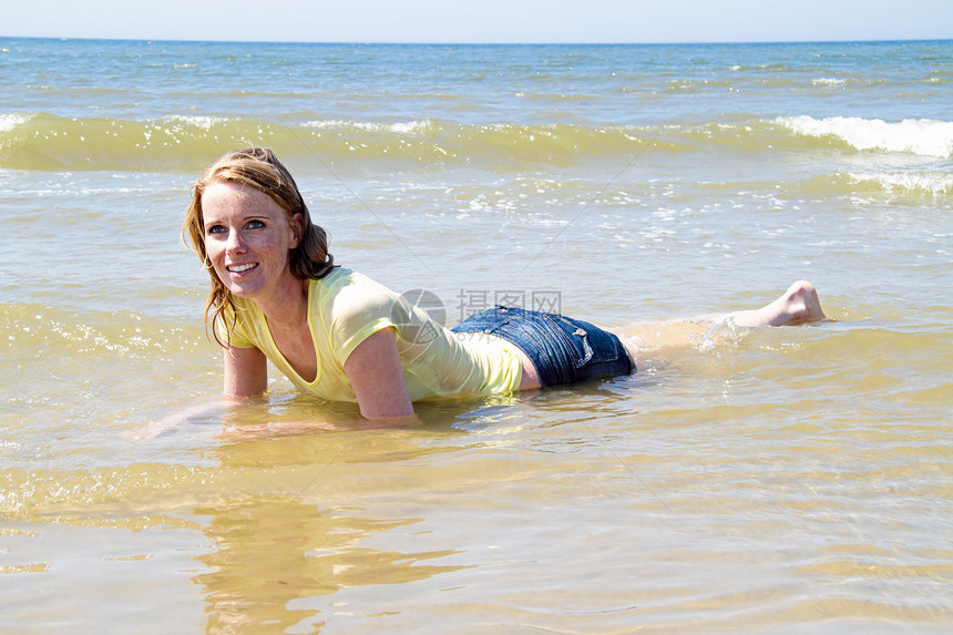 美丽的金发美女 在北海的海水中轻松放松女士享受头发日光浴身体女孩旅行泳装游泳衣蓝色图片