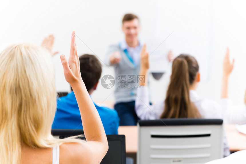 女性在班级中举起的手知识测验桌子老师训练教育工作学生女士青少年图片