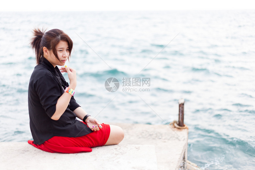 亚洲女性黑衬衫 坐在人行道上旅游海岸风景孤独支撑旅行白色海洋假期女士图片