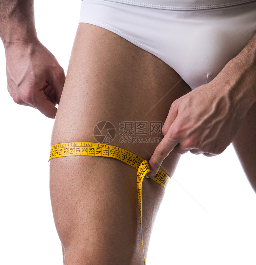 雄壮的年轻人用胶带测量大腿图片