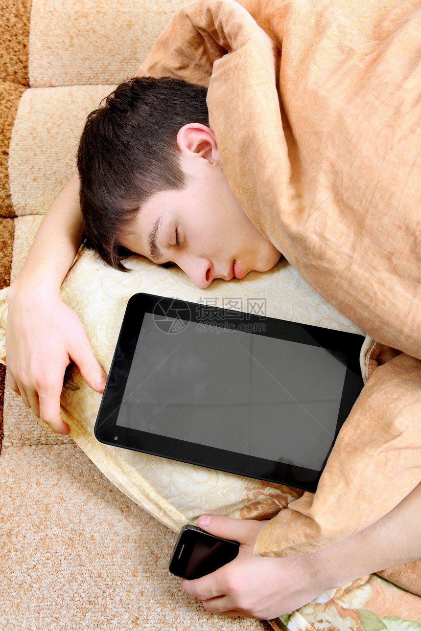 使用平板电脑的青少年睡眠男人被单工具倦怠沙发毯子瞌睡互联网药片房间图片