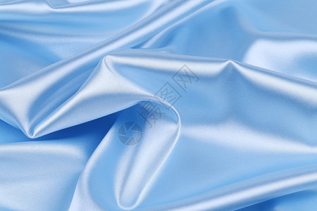 浅蓝色丝绸的柔软折叠和亮点衣服材料编织织物床单窗帘背景图片