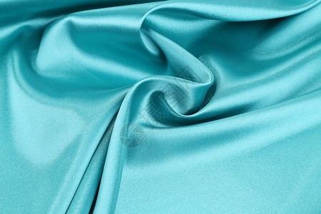 浅蓝色丝绸的柔软折叠和亮点织物床单编织窗帘材料衣服背景图片