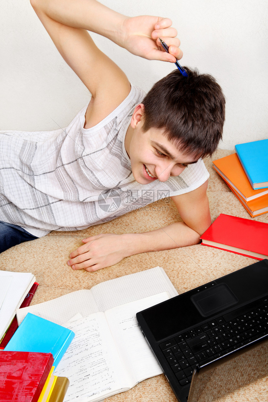 勤奋的青少年做家庭工作青年家庭作业电脑喜悦文书小伙子房间男人微笑图书图片