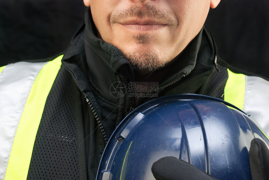 建筑工人把硬帽戴在胸前安全帽成人职场职业黑色安全工人工作头盔中年人图片