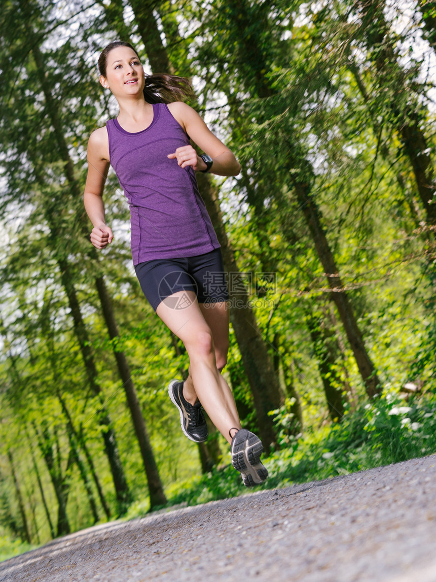 女人在森林里慢跑小路成人慢跑者身体树木女孩公园运动森林运动装图片