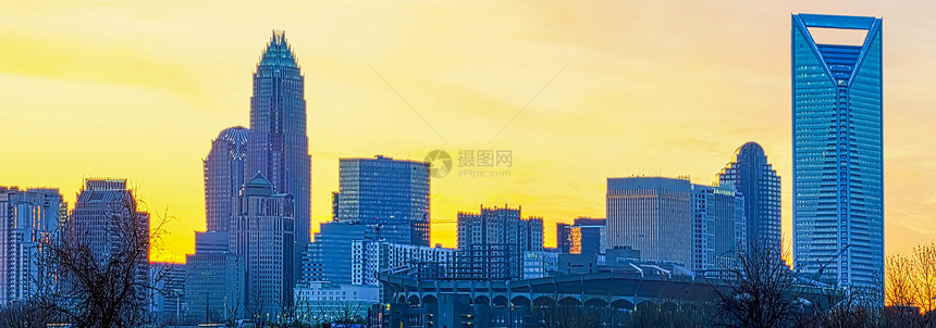 清晨黎明在市区Charlotte市天际线上日出全景天空黄色蓝色城市数控交通摩天大楼建筑学驾驶图片