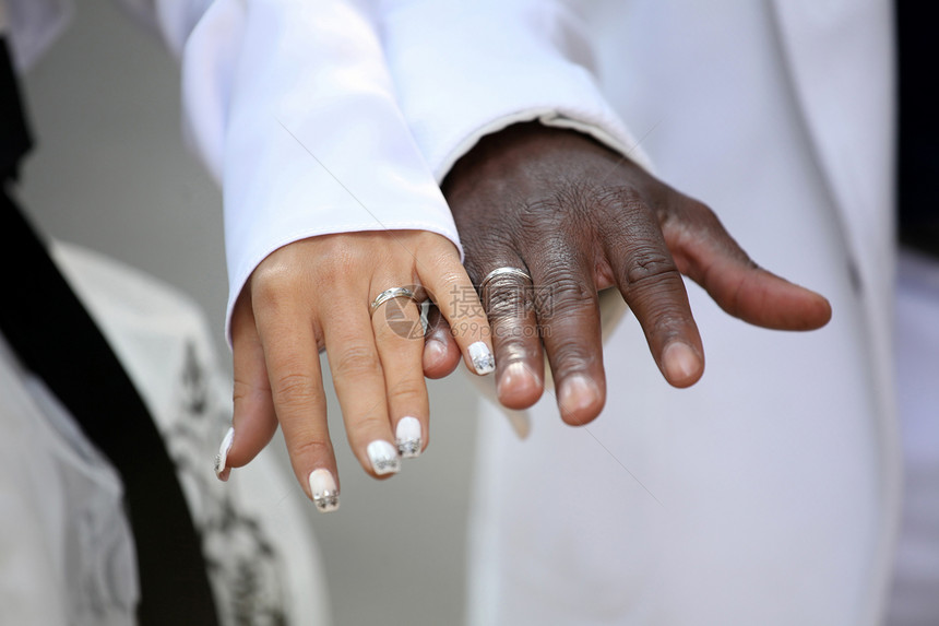 Causian人和非裔美国人夫妇手持戒指图片