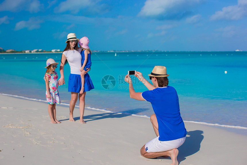 年青父亲在海滩上给家人打电话拍照 照片来自家人图片