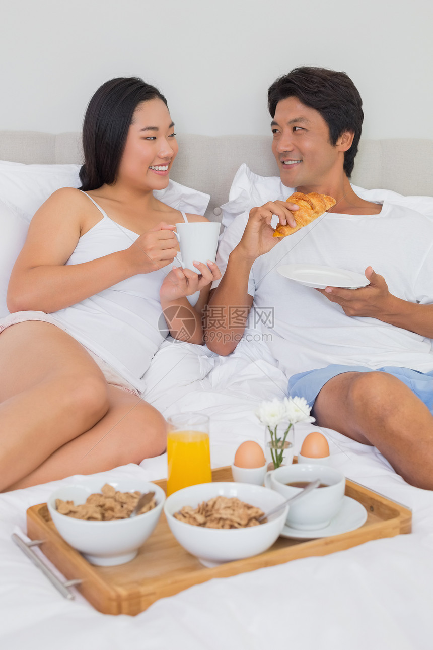 幸福的情侣在床上吃早餐家庭生活被子女士羽绒被睡衣女性热饮快乐闲暇男性图片