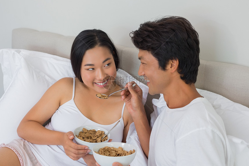 幸福的情侣在床上吃早餐房子女朋友男朋友勺子住所家庭闲暇羽绒被女性快乐图片
