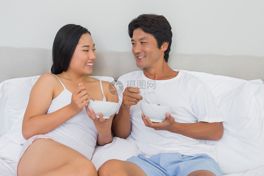 幸福的情侣在床上吃早餐休息快乐女性男人被子微笑睡衣家庭生活家庭住所图片