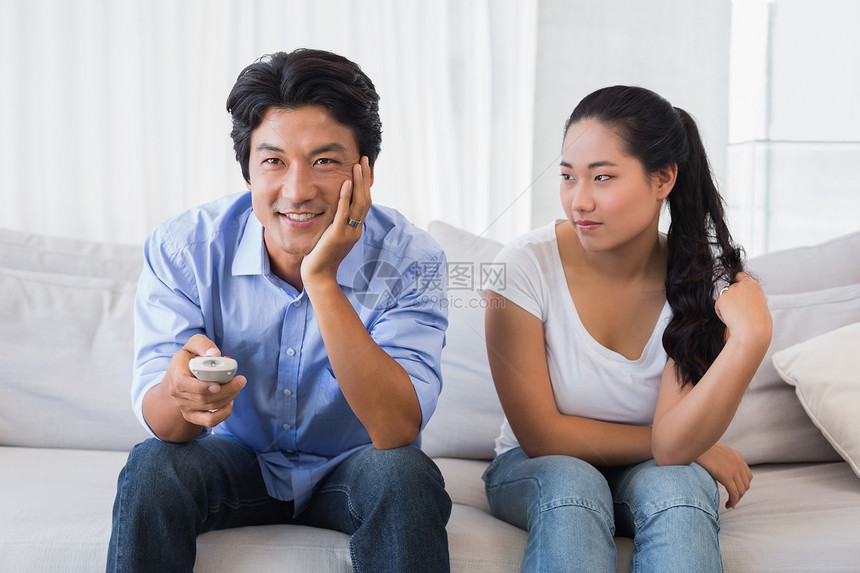 女人坐在沙发上 而男朋友看电视图片
