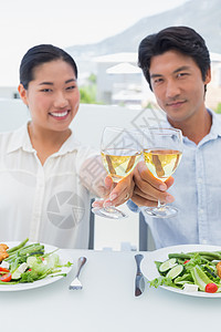 快乐的一对夫妇一起喝白酒吃饭房子女性公寓午餐时间家庭空闲女士酒精亲密感背景图片