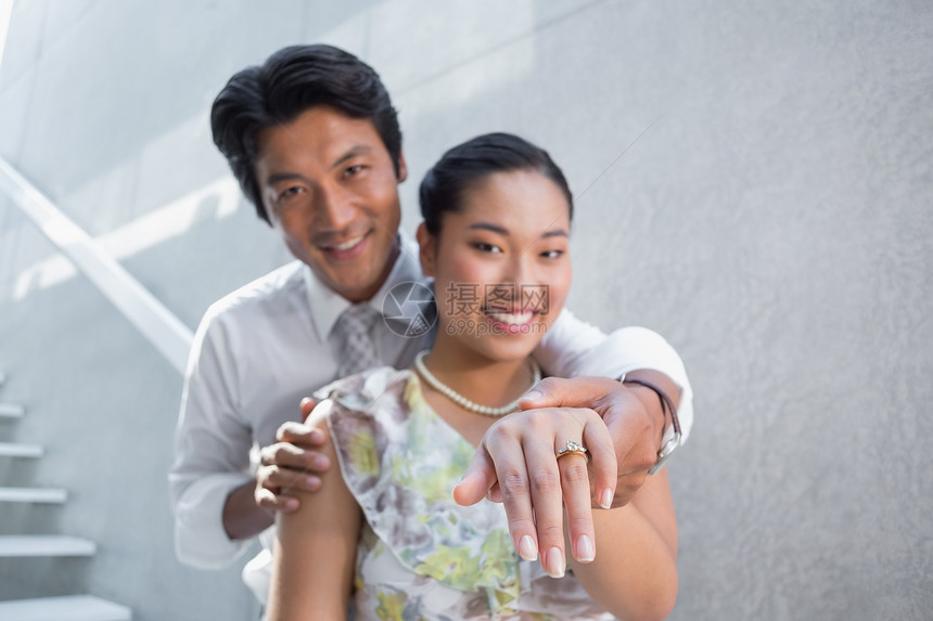 一对夫妇在女性手指上展示订婚戒指微笑闲暇快乐领带住所衬衫夫妻感情男人裙子图片