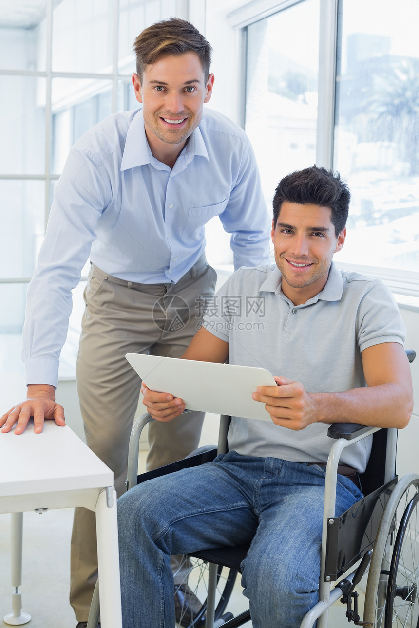 坐在轮椅上与同事笑着看镜头的随身商务人士图片