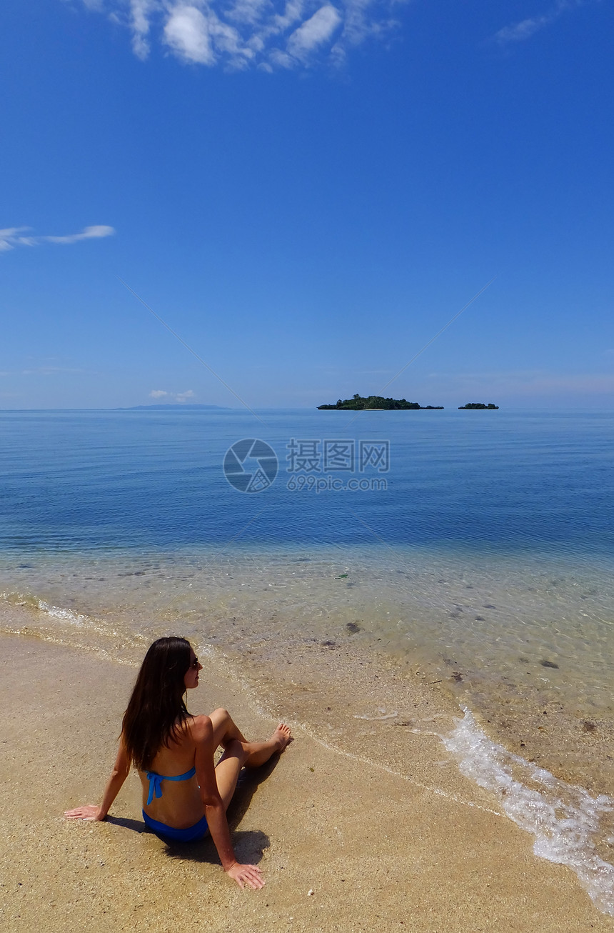 坐在菲济瓦努阿莱武岛沙滩上的比基尼青年妇女棕榈蓝色海洋海岸线海岸热带异国天堂情调海滩图片