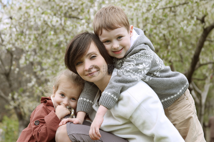 快乐的母亲和两个孩子拥抱父母季节女孩闲暇家庭幸福女儿兄弟儿子母性图片