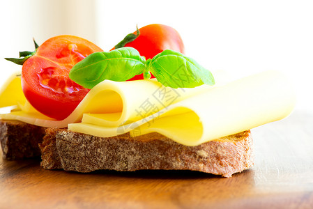 三明治加奶酪西红茄和烤肉小吃蔬菜早餐食物桌子叶子高清图片