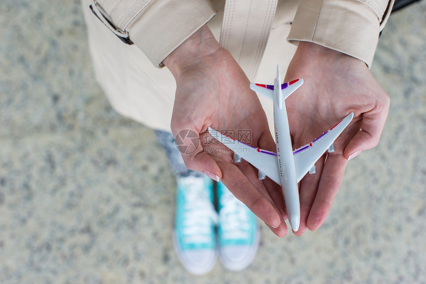 握着飞机型号的近手飞机场旅游货物游客公司天空喷射旅行航空公司翅膀图片