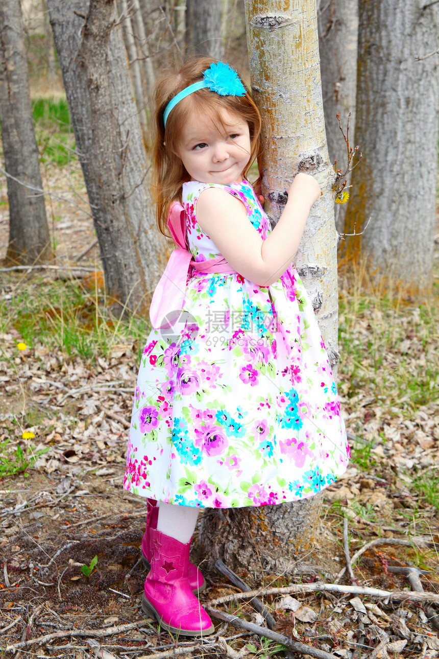 春天的女孩木头裙子快乐童年树叶花园树干日光孩子花朵图片