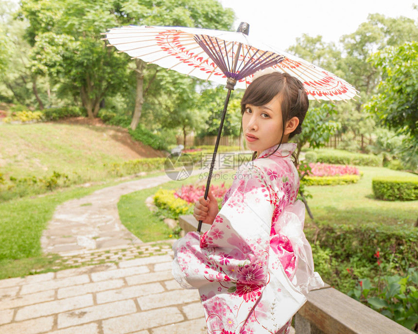 身穿浴衣 用日语拿伞的亚裔妇女图片