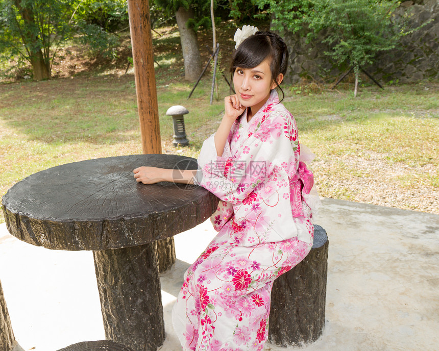 在日本花园穿和服的亚洲女人文化花园女士桌子椅子绿色浴衣女孩女性微笑图片