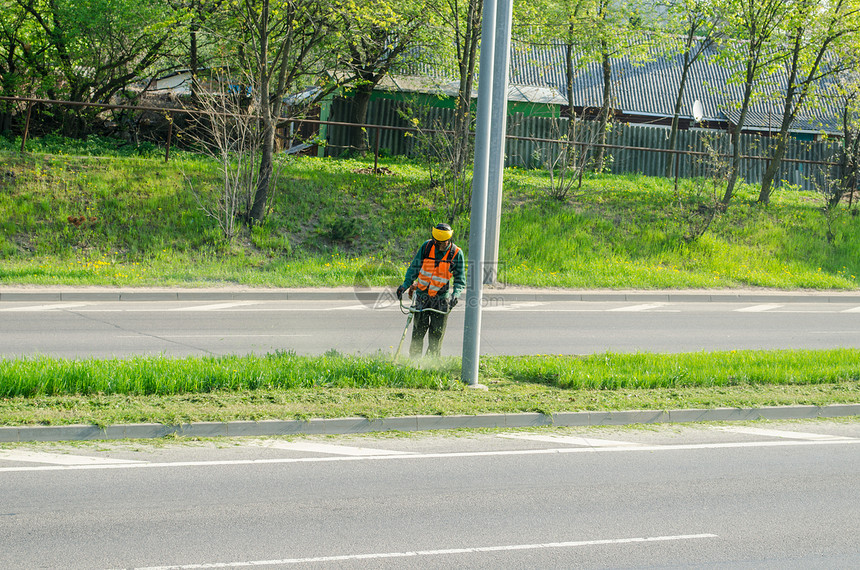工人用保护面罩割草铺路图片
