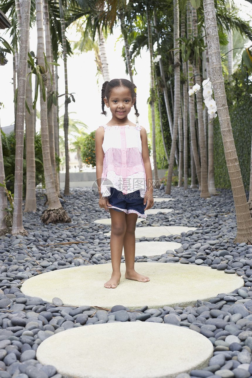 女孩(5-6岁)站在道路肖像上的踏脚石上图片