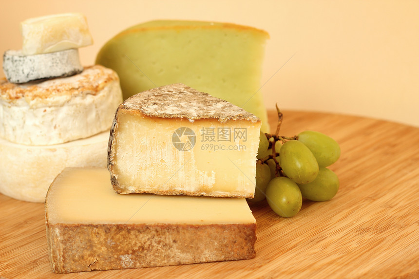 各种奶酪种类黄色模具木头白色奶制品绿色桌子圆形山羊美食图片